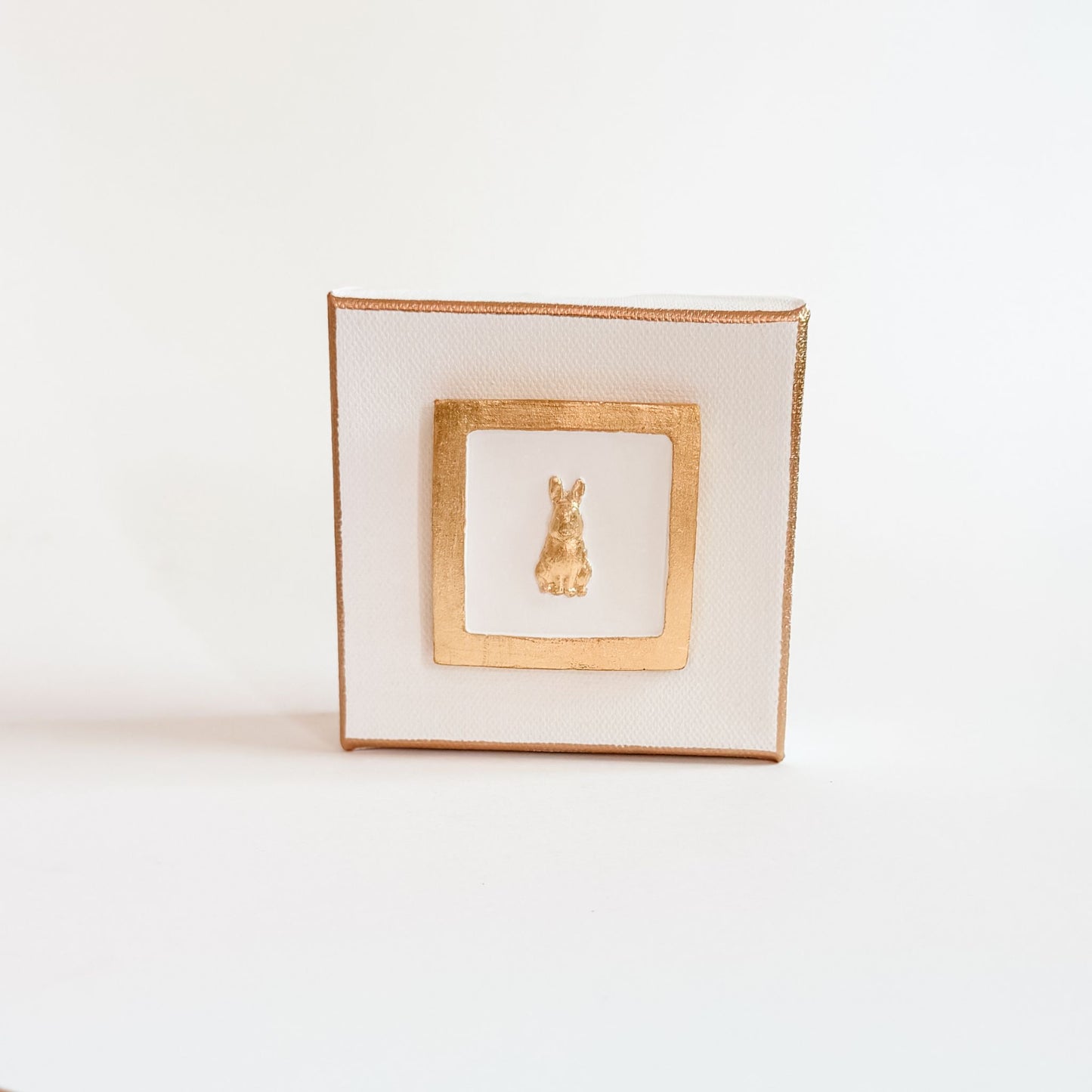 Decorative square plate with gold rim and central design on a white background