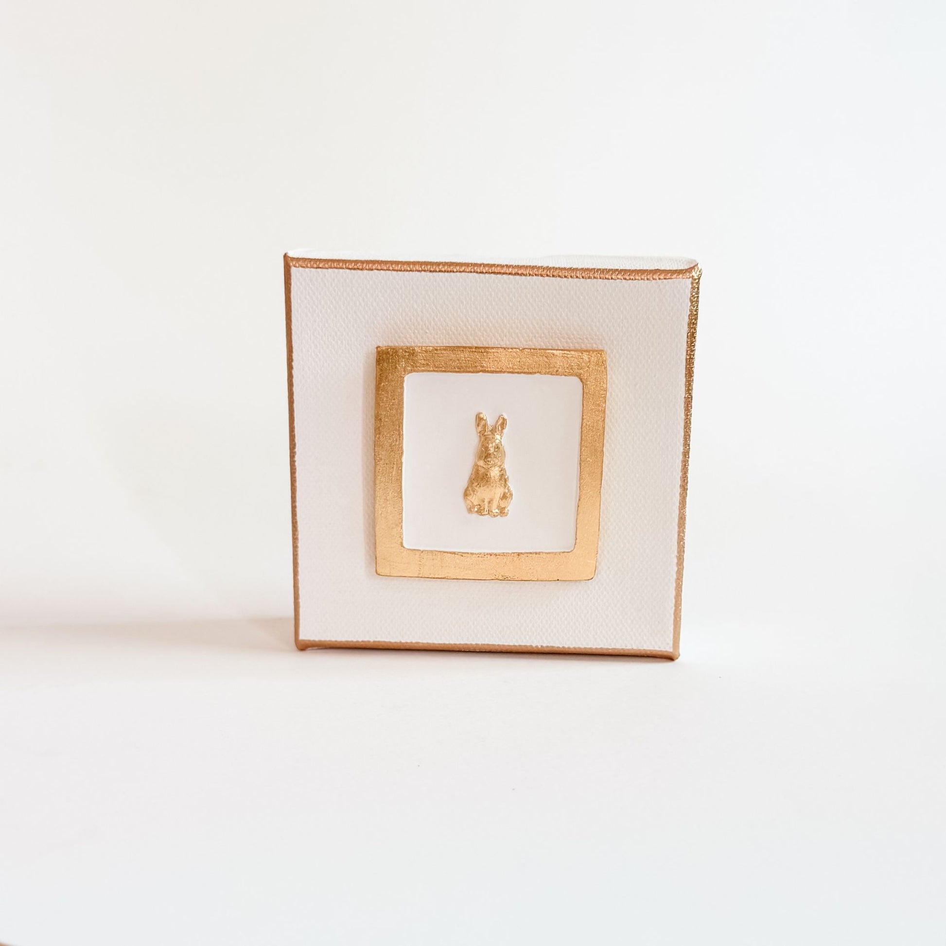 Decorative square plate with gold rim and central design on a white background