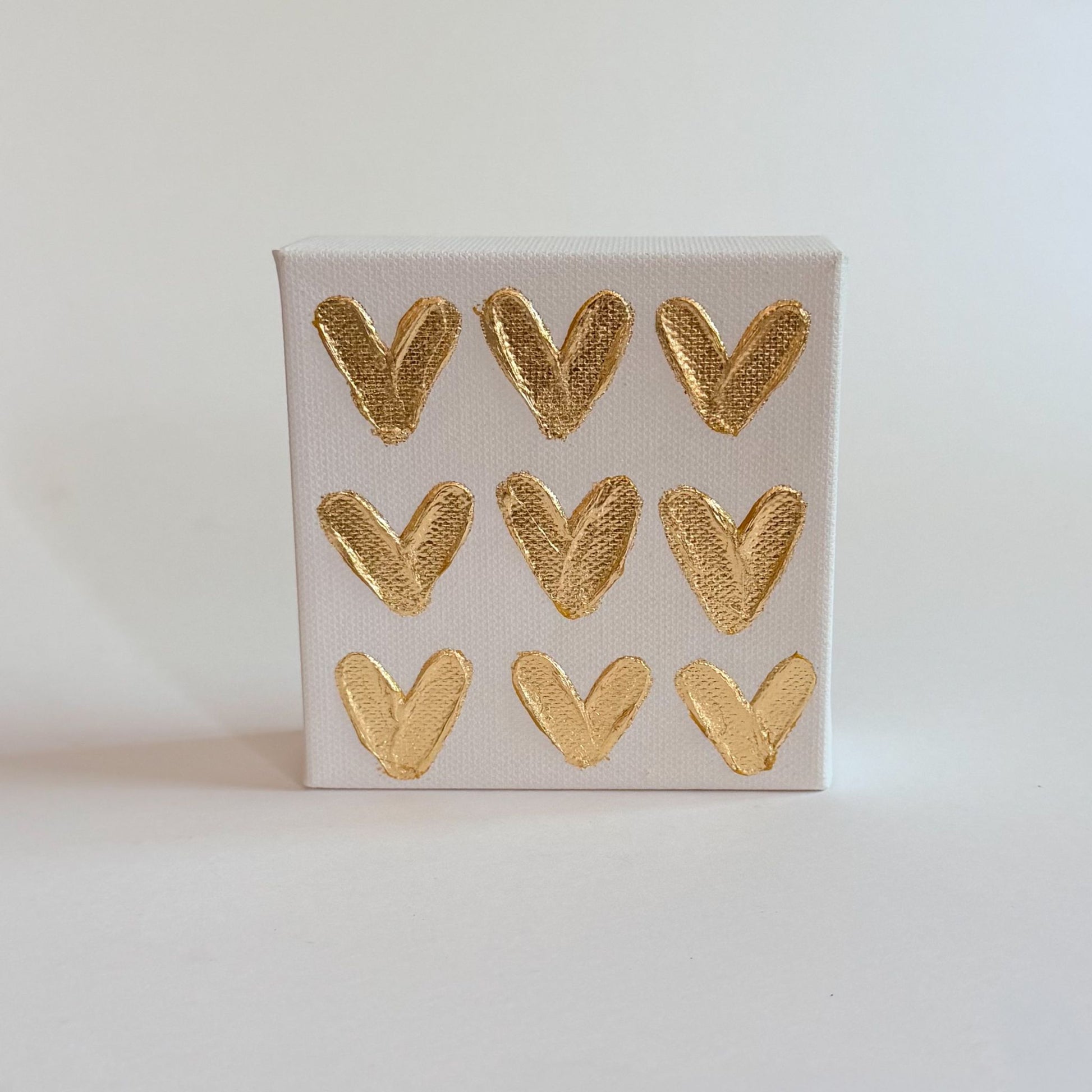 Small canvas with gold heart shapes on a light gray background