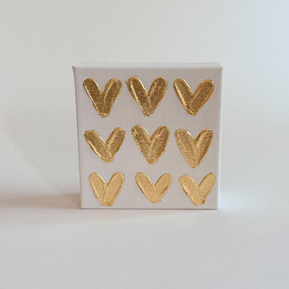 Small canvas with gold heart shapes on a light gray background