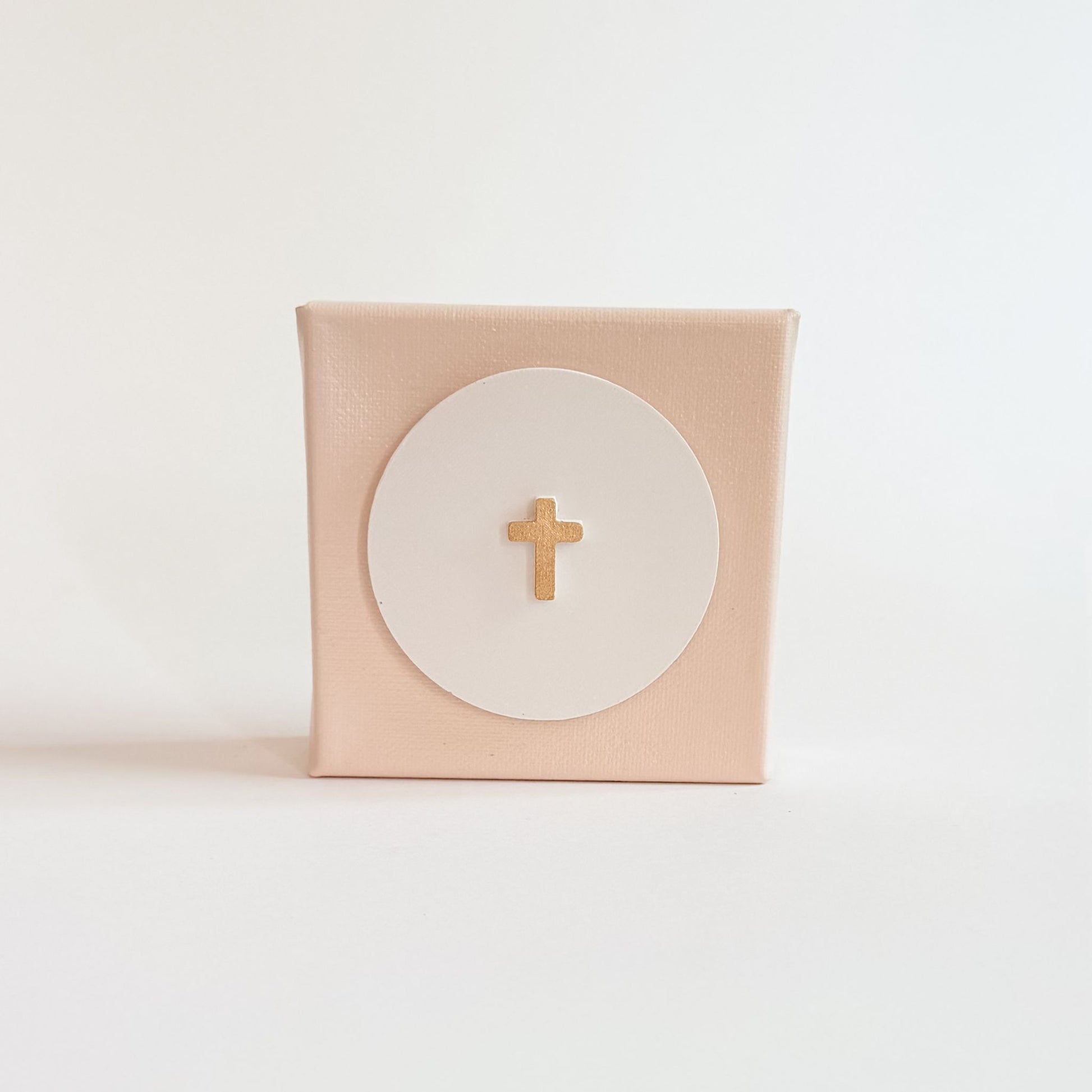Pink box with a gold cross on a white background