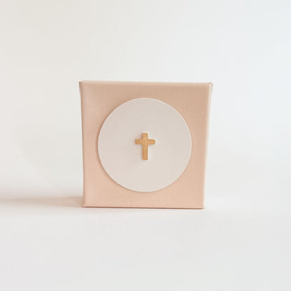 Pink box with a gold cross on a white background