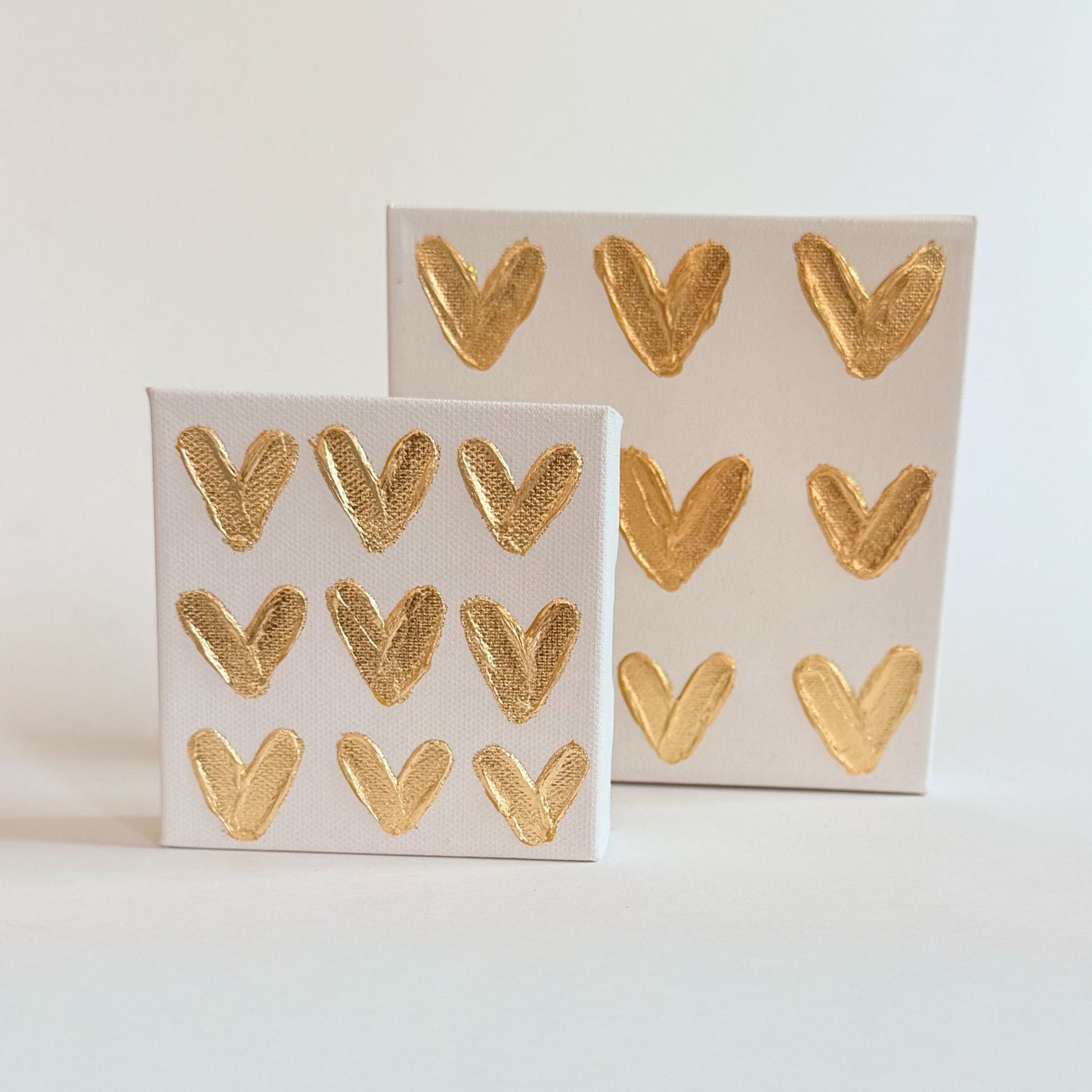 Two boxes of gold heart-shaped stickers on a light gray background